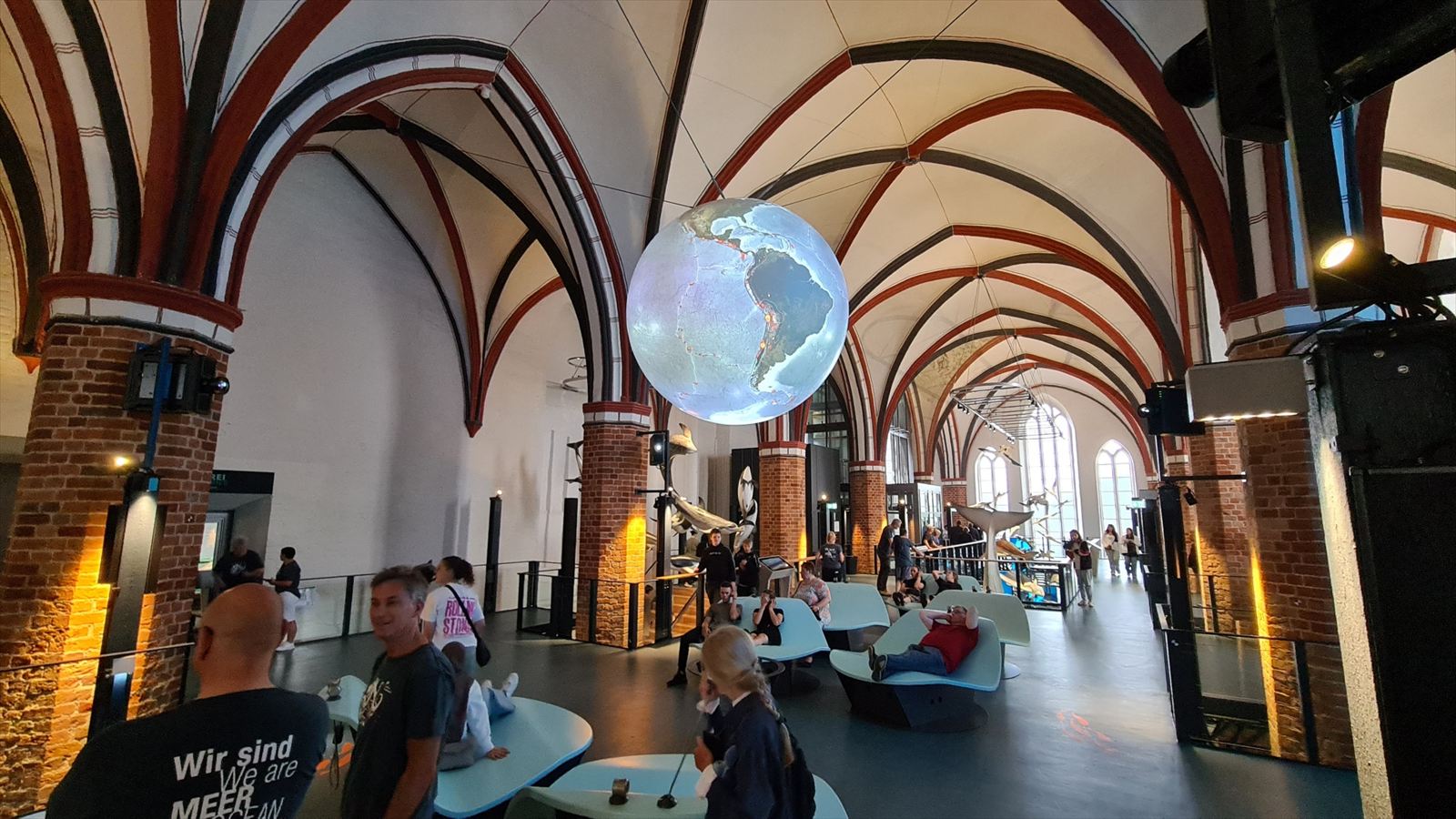 Leuchtende Globusprojektion unter dem gotischen Gewölbe des Meeresmuseums